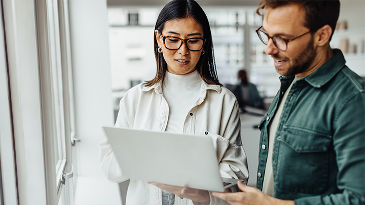 Two people working together on a laptop.